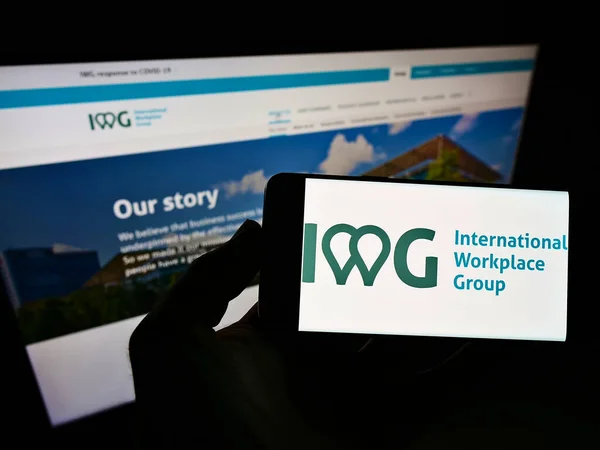 Stuttgart Germany 2021年5月18日 持有带有跨国服务办公室公司Iwg Plc标志的智能手机的人出现在网站前 专注于电话显示 — 图库照片