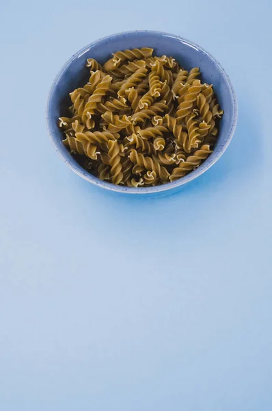 Vertikale Aufnahme Italienischer Fusilli Pasta Einer Blauen Schüssel Auf Blauem — Stockfoto