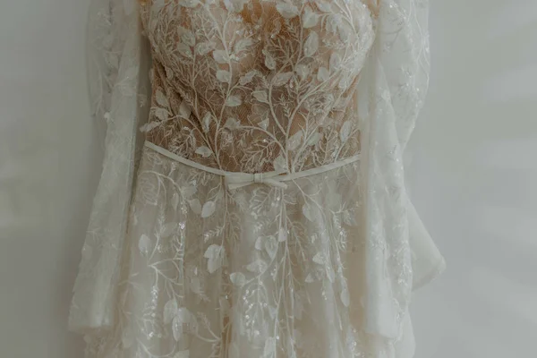 花嫁の結婚式のドレスは白い壁にかかっている — ストック写真