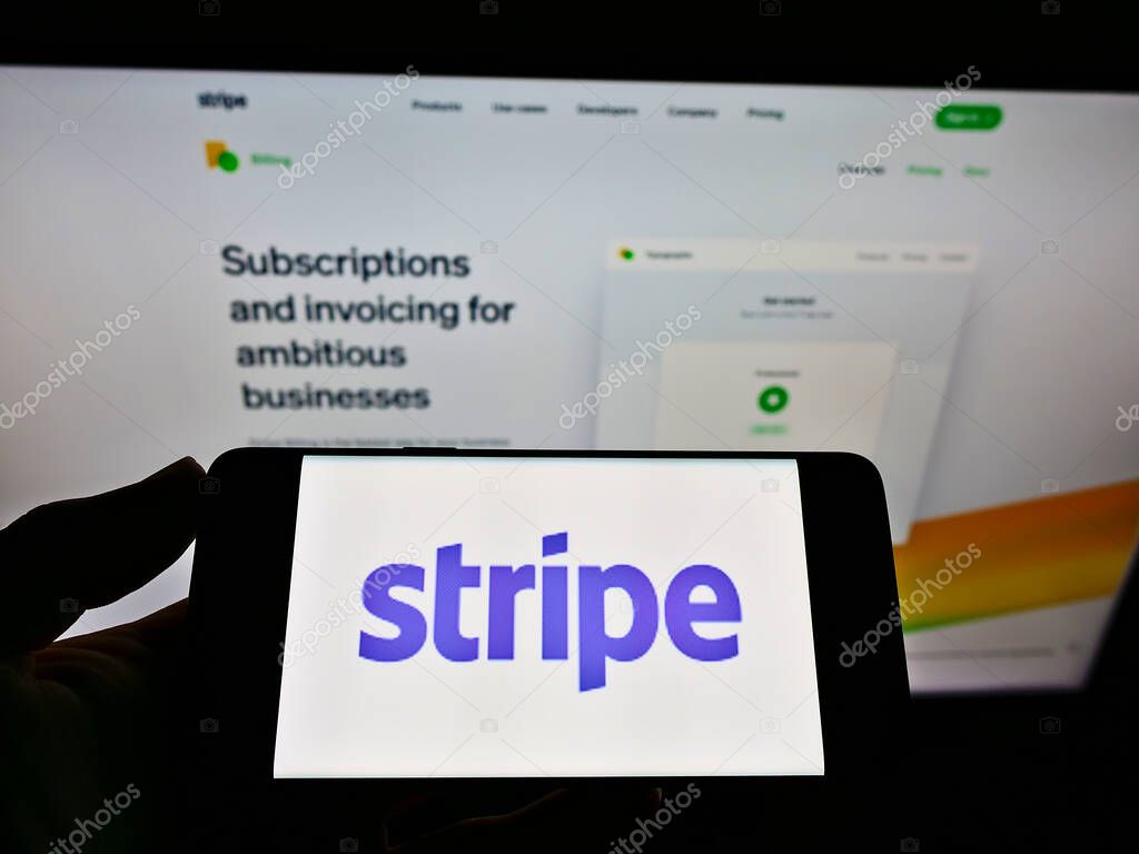 STUTTGART, GERMANY - May 26, 2021: Person holding smartphone with logo of Irish-US financial services company Stripe Inc. on screen in front of website. Focus on phone display.
