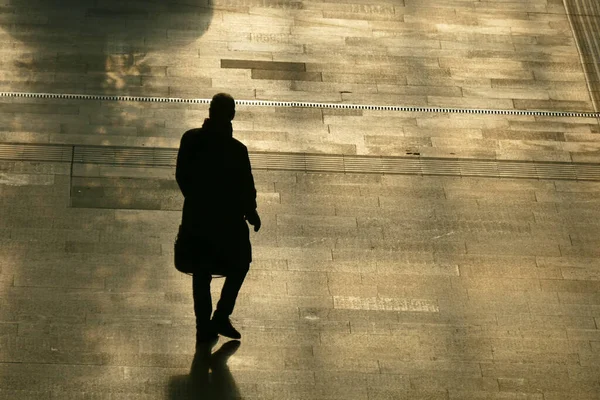 The silhouette of the lonely man walking on the street.