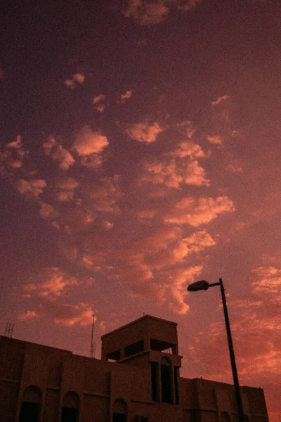 Eine Vertikale Aufnahme Eines Gebäudes Unter Dem Rosa Wolkenverhangenen Himmel — Stockfoto