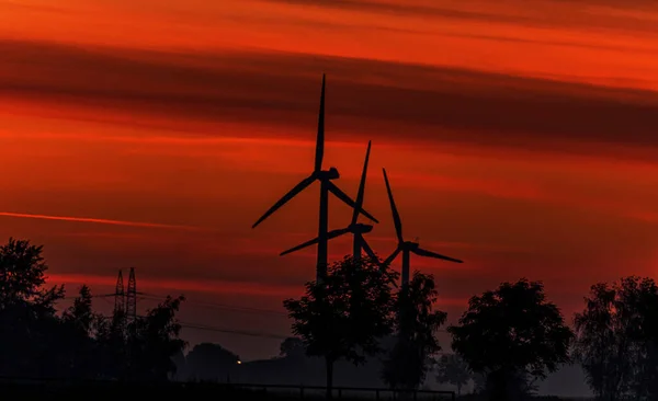 Eine Silhouette Von Windrädern Während Des Orangen Sonnenuntergangs — Stockfoto