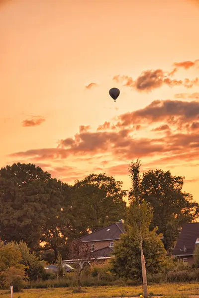 Pionowe Ujęcie Balonu Gorącego Powietrza Latającego Pomarańczowym Zachodzie Słońca Niebo — Zdjęcie stockowe