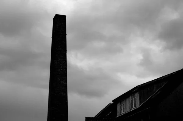 Eine Monochrome Aufnahme Eines Obelisken Und Eines Daches Vor Bewölktem — Stockfoto