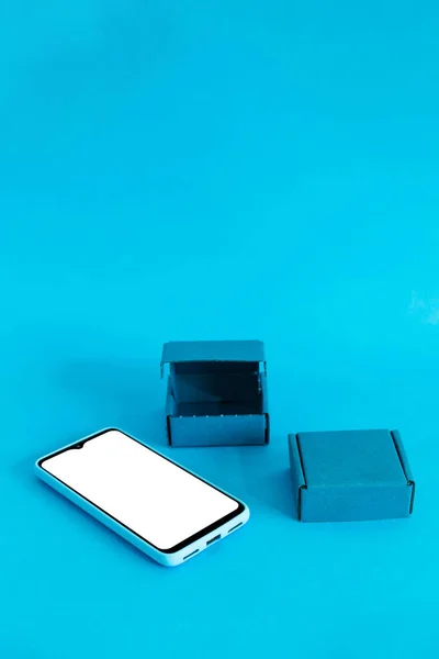Vertikal Bild Smartphone Och Två Lådor Isolerade Blå Bakgrund — Stockfoto