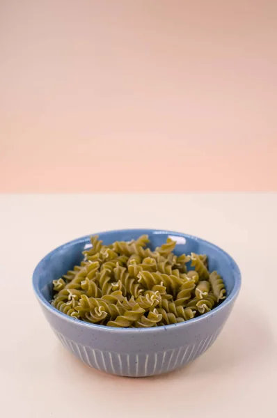 베이지 배경에 텍스트 파란색 그릇에 이탈리아식 파스타의 — 스톡 사진
