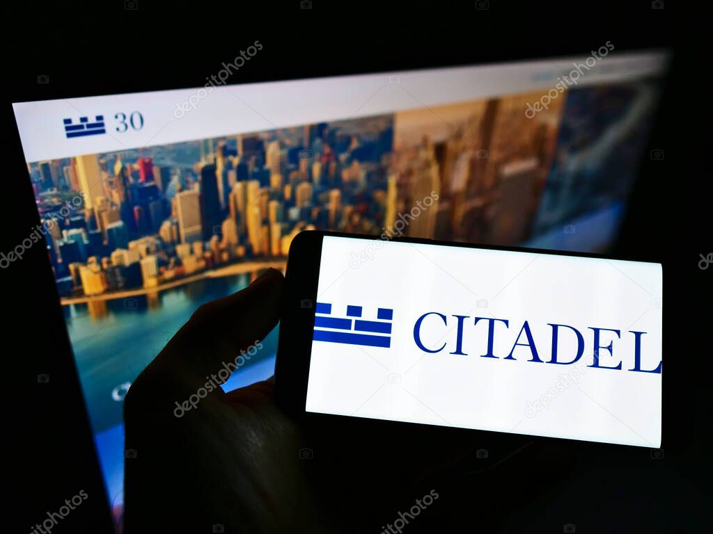 STUTTGART, GERMANY - Mar 03, 2021: Person holding mobile phone with logo of American hedge fund company Citadel LLC on screen in front of business web page. Focus on phone display.