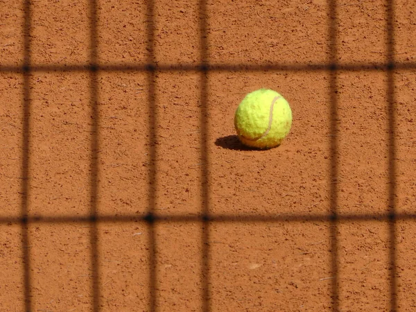 Egy Közeli Felvétel Egy Sárga Teniszlabdáról Egy Teniszagyagon Ellenőrzött Árnyékokkal — Stock Fotó