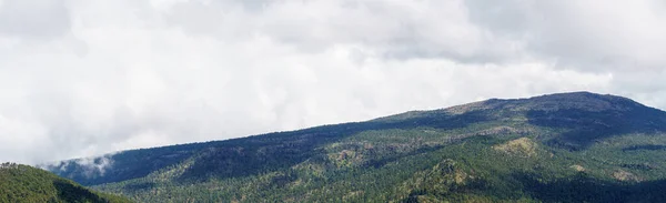 Панорамный Снимок Туманного Облачного Неба Зеленом Холме Зеленой Горой Заднем — стоковое фото