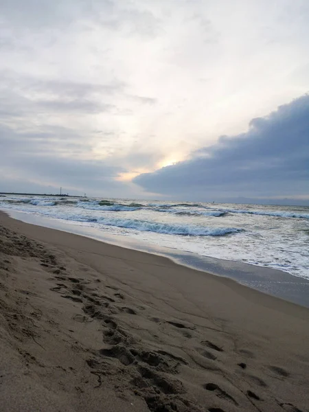 Вид Волнистое Море Закате Мокрый Песок Ступеньками Облачным Небом — стоковое фото