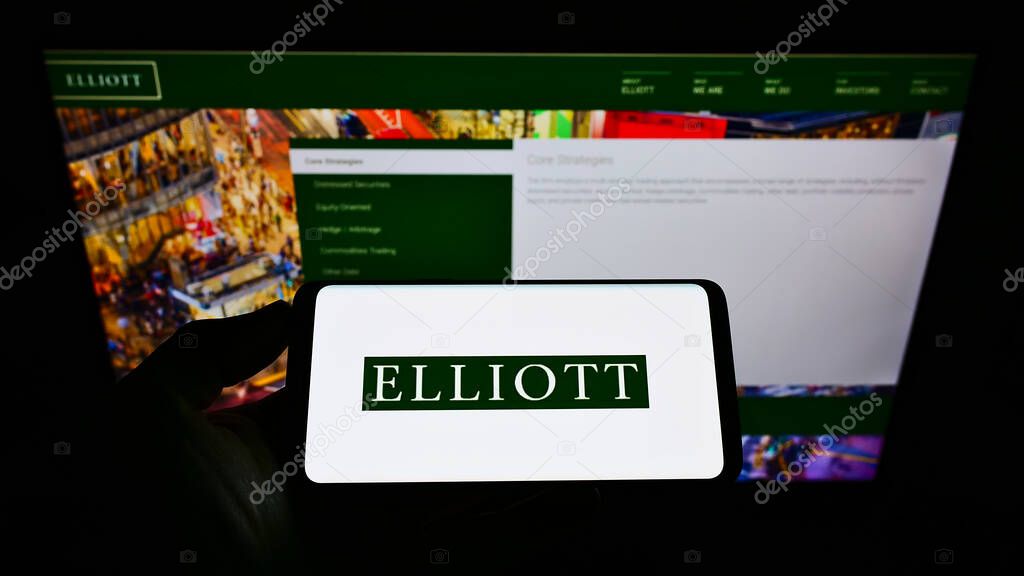 STUTTG, GERMANY - Jun 08, 2021: Person holding cellphone with logo of American investment firm Elliott Management Corporation on screen in front of website. Focus on phone display.