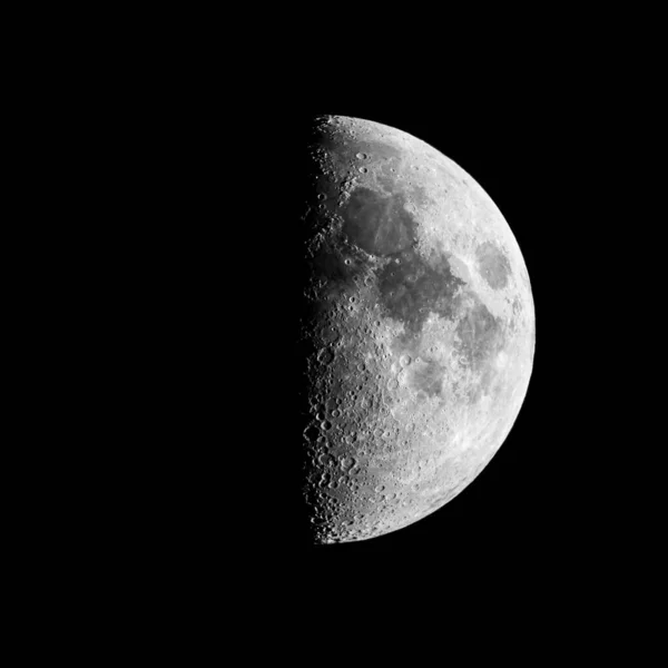 A beautiful textured gray half moon in a black sky