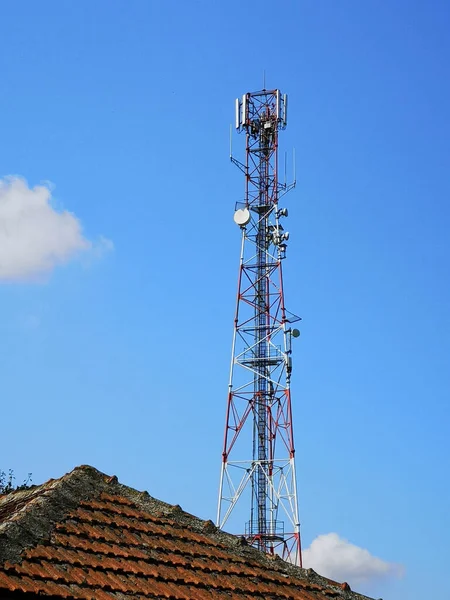Uma Torre Transmissão Antena Perto Telhado Edifício Contra Céu Azul — Fotografia de Stock