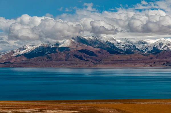 地平线上的棕色海岸 蓝色的海水和雪山的美丽景色 — 图库照片