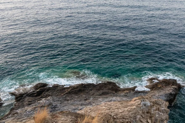 在阳光灿烂的日子里 蔚蓝的海水波涛中 岩石悬崖顶上的美丽景色 — 图库照片