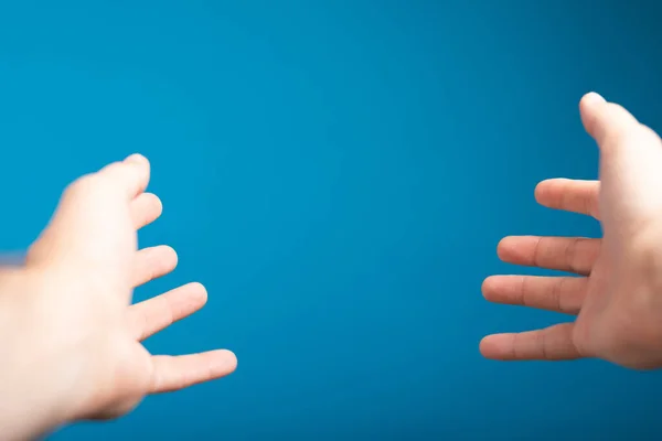 Duas Mãos Estendidas Sobre Fundo Azul — Fotografia de Stock