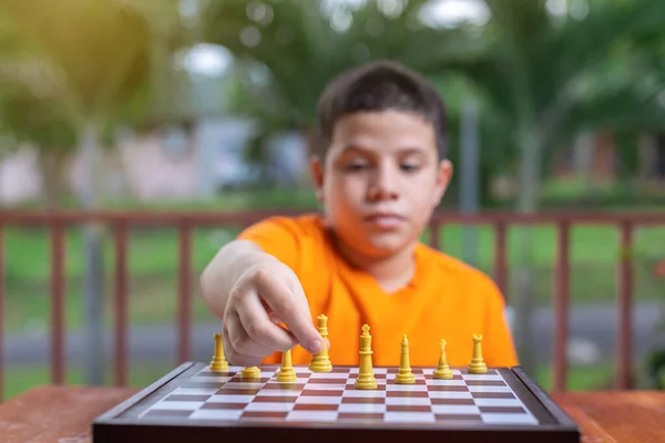 Ένα Αγόρι Πορτοκαλί Μπλουζάκι Που Παίζει Σκάκι — Φωτογραφία Αρχείου