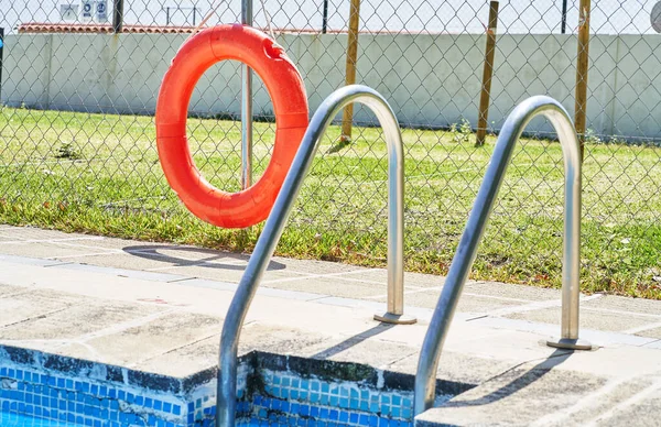 Yüzme Havuzunun Paslanmaz Çelik Korkulukların Kırmızı Bir Yüzme Halkasının Yakın — Stok fotoğraf
