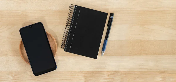 Μια Κορυφαία Άποψη Ενός Μαύρου Smartphone Σημειωματάριο Και Στυλό Ένα — Φωτογραφία Αρχείου