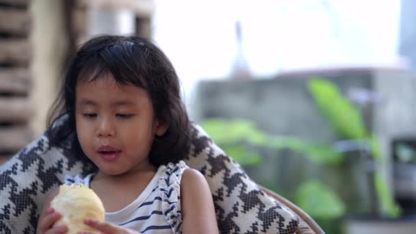 Little Asian Girl Eating Something Delicious — Stockvideo