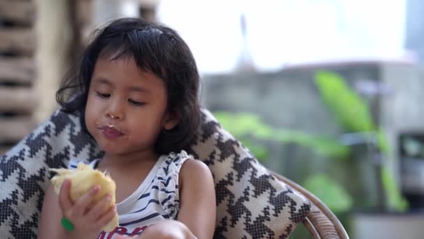 Little Asian Girl Eating Something Delicious — Stockvideo