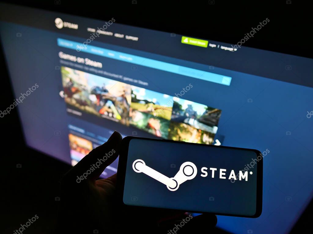 STUTTGART, GERMANY - Feb 19, 2021: Person holding smartphone with logo of distribution platform Steam operated by Valve on screen in front of website. Focus on phone display.