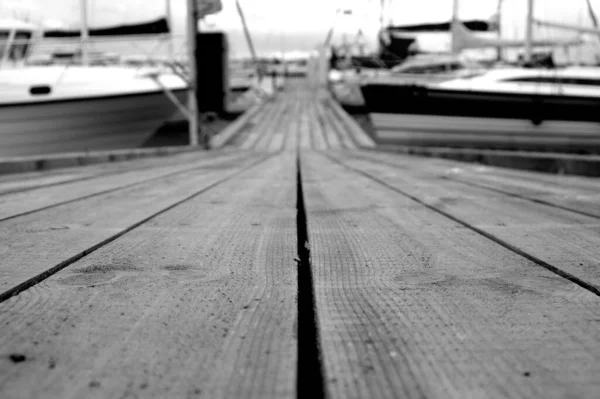 Grayscale Shot Wooden Dock Surrounded Boats Port Daylight — Stock Photo, Image