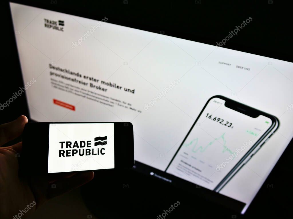 STUTTGART, GERMANY - Sep 13, 2021: Person holding smartphone with logo of German online broker Trade Republic Bank GmbH on screen in front of website. Focus on phone display.
