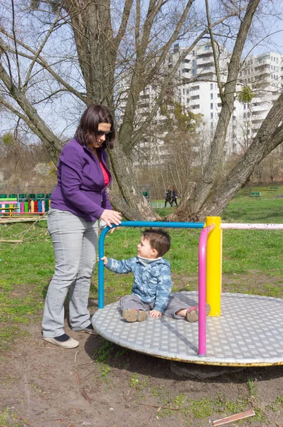 波兰波兹南 波兹南 2016年4月4日 一位母亲和她的儿子在波兹南公园的转盘上玩耍 — 图库照片