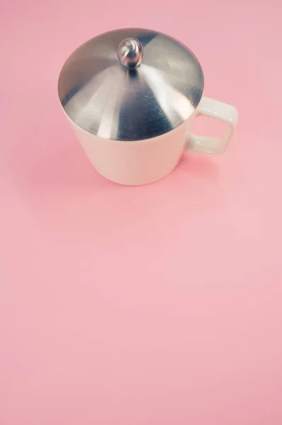 ピンクの背景に蓋のある白いマグカップのクローズアップ — ストック写真