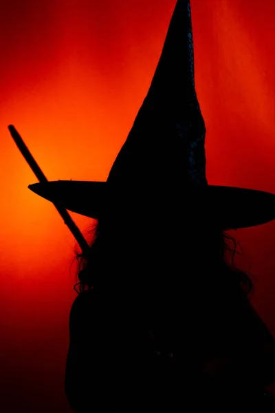 Vertikální Záběr Siluety Čarodějnice Její Hůlkou Halloween Červeno Oranžovém Pozadí — Stock fotografie