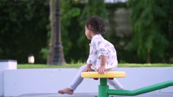 Cute Little Girl Spinning Playground — стоковое видео