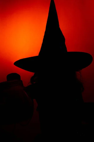 Vertikální Záběr Siluety Čarodějnice Její Hůlkou Halloween Červeno Oranžovém Pozadí — Stock fotografie