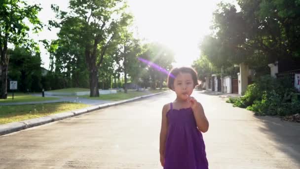 Young Girl Walking Park Eating Lollipop — стоковое видео