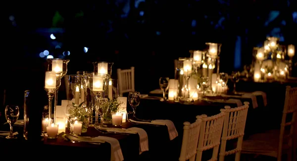 An illuminated restaurant with white candles at night