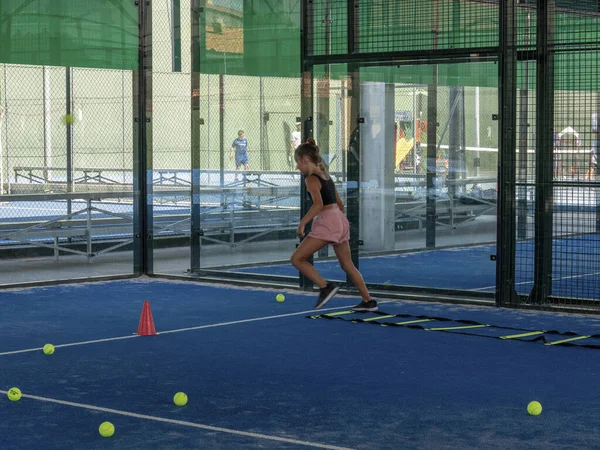 A young Caucasian teenage girl doing an agility ladder drill training at a sports club