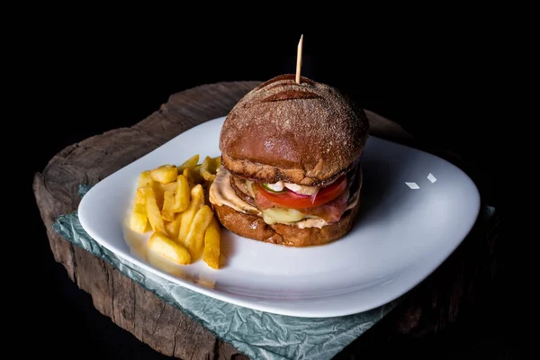 Delicious Hamburger French Fries White Plate Tree Trunk Black Background — Stock Photo, Image