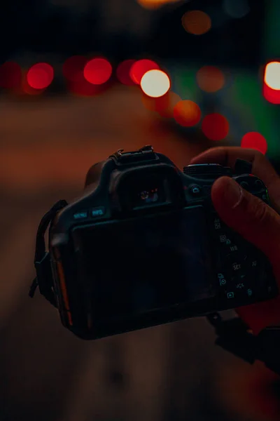 Tiro Vertical Uma Mão Segurando Uma Câmera Profissional Com Luzes — Fotografia de Stock