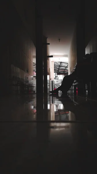 Vertical Shot Silhouette Person Sitting Bench Waiting Dark Hallway — Stock Photo, Image