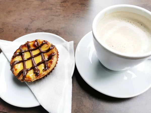 Ένα Σφηνάκι Καφέ Και Ένα Επιδόρπιο Καλυμμένο Σοκολάτα Ένα Τραπέζι — Φωτογραφία Αρχείου