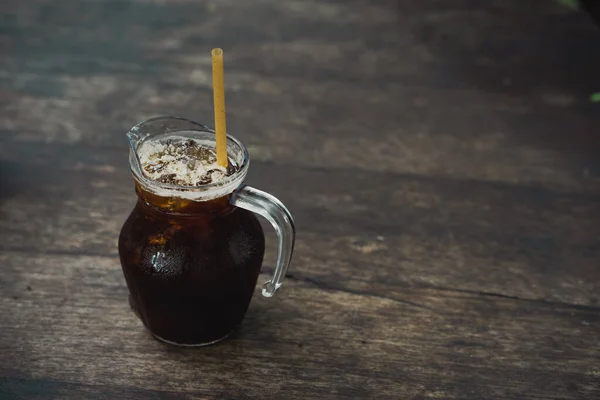 Närbild Glaskanna Med Iskaffe Och Ett Gult Sugrör Träyta — Stockfoto