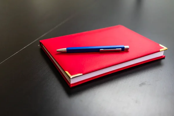 Крупный План Красной Тетради Синей Ручкой Столе — стоковое фото