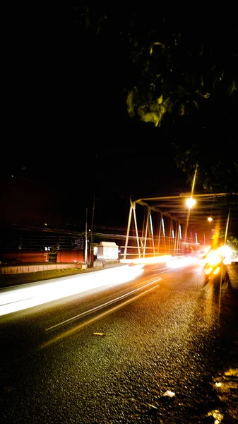 夜間に長時間露光する道路を走行する車の垂直ショット — ストック写真
