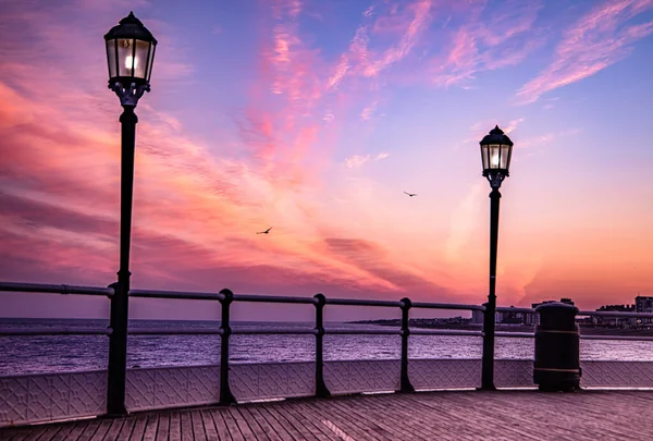 街灯のある桟橋の上の美しいピンクの夕日の空 — ストック写真