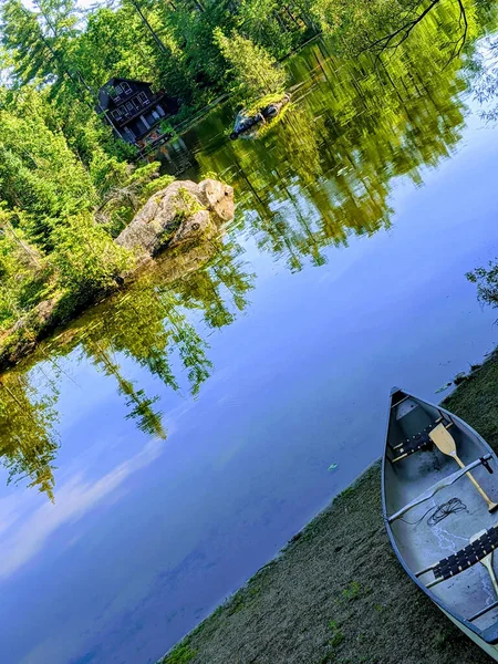 Dřevěný Člun Břehu Zrcadlové Jezero Odrazem Zeleného Okolí — Stock fotografie