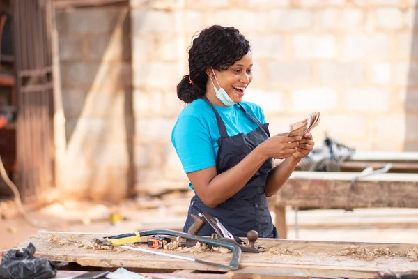 A closeup shot of a beautiful African carpenter female in her workshop