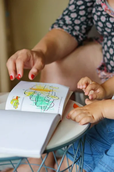 波兹南 2017年6月24日 一个母亲和孩子在桌上的一本小书里拼凑了一个卡车图解 — 图库照片