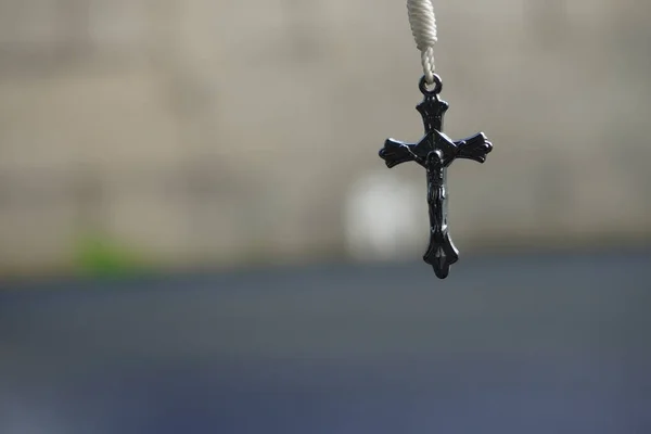 悬吊的黑色基督教十字架交叉项链吊坠的选择性聚焦镜头 — 图库照片