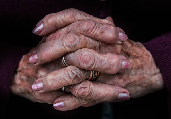 Mãos Cruzadas Uma Senhora Idosa Com Manicure Rosa Anéis — Fotografia de Stock